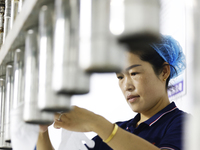 A worker produces disposable PVC gloves for domestic and international markets at a workshop of a foreign-funded enterprise in Suqian, China...