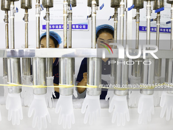 Workers make disposable PVC gloves for domestic and international markets at a production workshop of a foreign-funded enterprise in Suqian,...