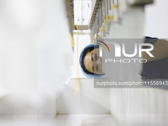 A worker produces disposable PVC gloves for domestic and international markets at a workshop of a foreign-funded enterprise in Suqian, China...