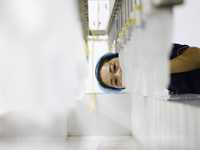 A worker produces disposable PVC gloves for domestic and international markets at a workshop of a foreign-funded enterprise in Suqian, China...