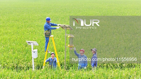 Workers inspect intelligent agricultural monitoring equipment and guide farmers to use it in Chuzhou, China, on September 7, 2024. 