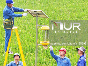 Workers inspect intelligent agricultural monitoring equipment and guide farmers to use it in Chuzhou, China, on September 7, 2024. (