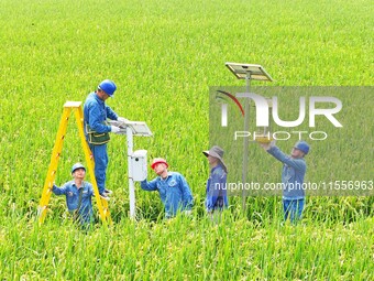 Workers inspect intelligent agricultural monitoring equipment and guide farmers to use it in Chuzhou, China, on September 7, 2024. (