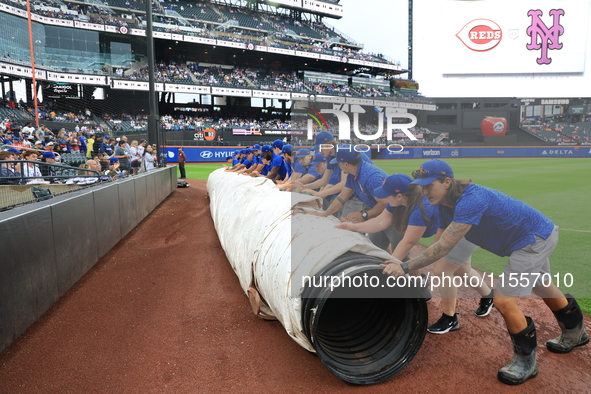 The New York Mets grounds crew prepares the field before the baseball game between the Cincinnati Reds and New York Mets at Citi Field in Co...