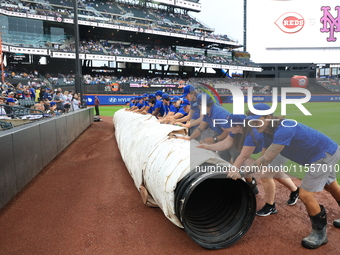 The New York Mets grounds crew prepares the field before the baseball game between the Cincinnati Reds and New York Mets at Citi Field in Co...