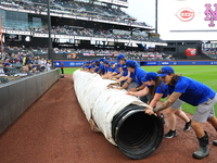 The New York Mets grounds crew prepares the field before the baseball game between the Cincinnati Reds and New York Mets at Citi Field in Co...