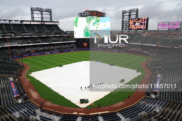 The New York Mets grounds crew prepares the field before the baseball game between the Cincinnati Reds and New York Mets at Citi Field in Co...