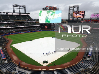 The New York Mets grounds crew prepares the field before the baseball game between the Cincinnati Reds and New York Mets at Citi Field in Co...