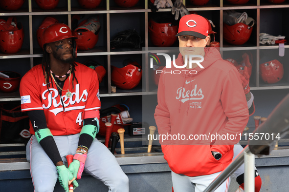 Cincinnati Reds Elly De La Cruz #44 and manager David Bell #25 stand in the dugout before the baseball game against the New York Mets at Cit...