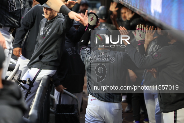 Brandon Nimmo #9 of the New York Mets is congratulated in the dugout after scoring during the sixth inning of the baseball game against the...