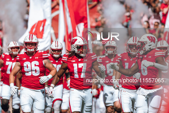 Wisconsin Badgers outside linebacker Darryl Peterson #17 fist bumps outside linebacker Leon Lowery Jr. #8 as the Wisconsin Badgers take the...