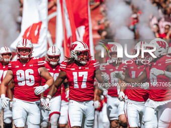 Wisconsin Badgers outside linebacker Darryl Peterson #17 fist bumps outside linebacker Leon Lowery Jr. #8 as the Wisconsin Badgers take the...