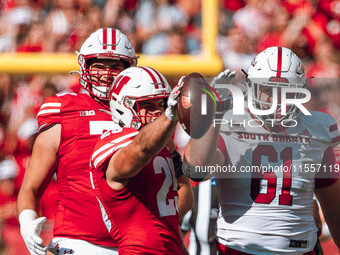 Wisconsin Badgers running back Cade Yacamelli #25 celebrates a first down in the face of South Dakota defensive lineman Blake Holden #61 at...