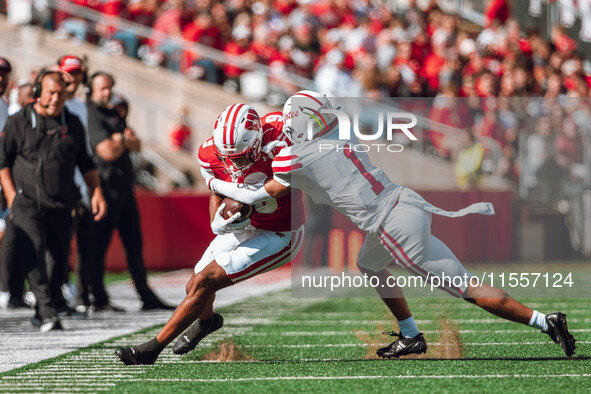 South Dakota defensive back Roman Tillmon #1 tackles Wisconsin Badgers wide receiver Bryson Green #9 at Camp Randall Stadium in Madison, Wis...