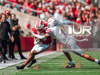 South Dakota defensive back Roman Tillmon #1 tackles Wisconsin Badgers wide receiver Bryson Green #9 at Camp Randall Stadium in Madison, Wis...