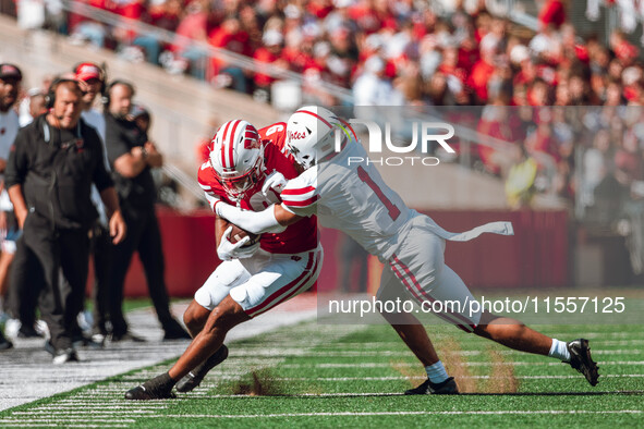 South Dakota defensive back Roman Tillmon #1 tackles Wisconsin Badgers wide receiver Bryson Green #9 at Camp Randall Stadium in Madison, Wis...