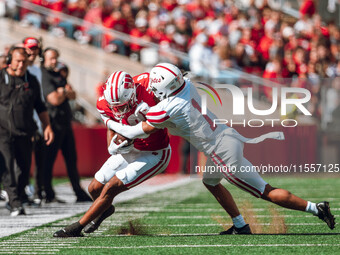 South Dakota defensive back Roman Tillmon #1 tackles Wisconsin Badgers wide receiver Bryson Green #9 at Camp Randall Stadium in Madison, Wis...