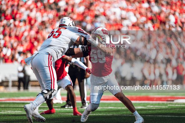 Wisconsin Badgers outside linebacker Aaron Witt #59 takes on South Dakota offensive lineman Bryce Henderson #55 at Camp Randall Stadium in M...