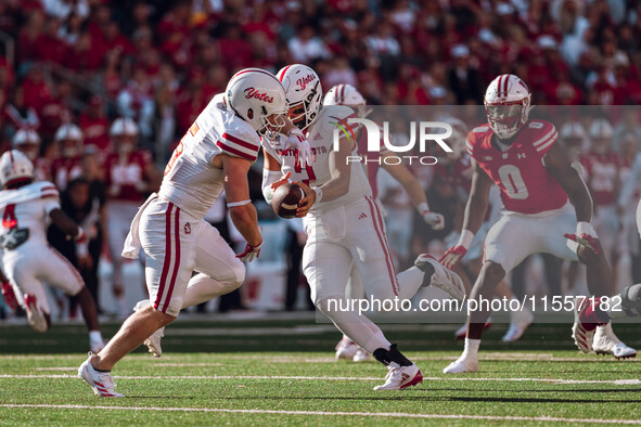 South Dakota quarterback Aidan Bouman #2 fakes a handoff to running back Travis Theis #5 at Camp Randall Stadium in Madison, Wisconsin, on S...