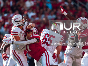 South Dakota quarterback Aidan Bouman #2 attempts a pass against the pressure of Wisconsin Badgers outside linebacker Darryl Peterson #17 at...