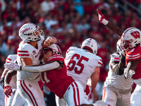 South Dakota quarterback Aidan Bouman #2 attempts a pass against the pressure of Wisconsin Badgers outside linebacker Darryl Peterson #17 at...