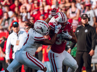 South Dakota defensive back Teven McKelvey #3 grabs the facemask of Wisconsin Badgers running back Jackson Acker #34 at Camp Randall Stadium...