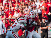 South Dakota defensive back Teven McKelvey #3 grabs the facemask of Wisconsin Badgers running back Jackson Acker #34 at Camp Randall Stadium...