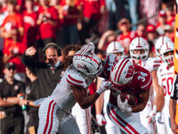 South Dakota defensive back Teven McKelvey #3 grabs the facemask of Wisconsin Badgers running back Jackson Acker #34 at Camp Randall Stadium...