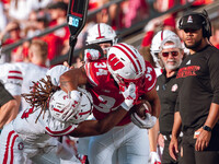 South Dakota defensive back Teven McKelvey #3 grabs the facemask of Wisconsin Badgers running back Jackson Acker #34 at Camp Randall Stadium...