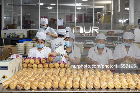 Workers pack mooncakes at a workshop of Oriental Pastry Co., LTD., a time-honored pastry company in Taizhou, China, on September 8, 2024. 