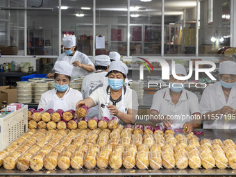 Workers pack mooncakes at a workshop of Oriental Pastry Co., LTD., a time-honored pastry company in Taizhou, China, on September 8, 2024. (