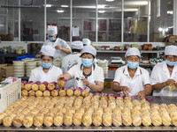 Workers pack mooncakes at a workshop of Oriental Pastry Co., LTD., a time-honored pastry company in Taizhou, China, on September 8, 2024. (