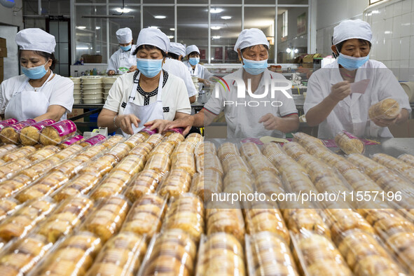 Workers pack mooncakes at a workshop of Oriental Pastry Co., LTD., a time-honored pastry company in Taizhou, China, on September 8, 2024. 