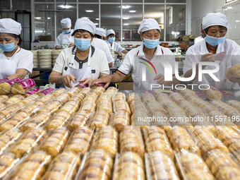 Workers pack mooncakes at a workshop of Oriental Pastry Co., LTD., a time-honored pastry company in Taizhou, China, on September 8, 2024. (