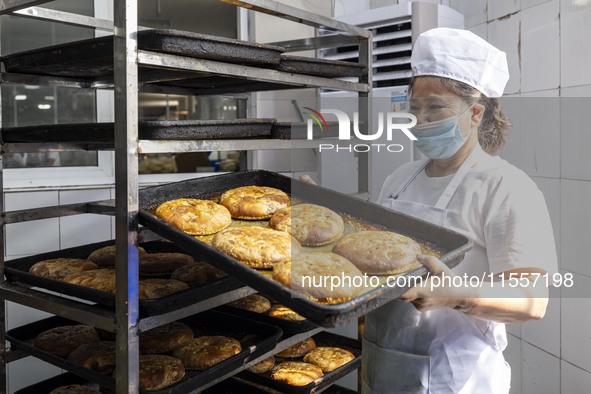 A worker prepares mooncakes for packaging at the production workshop of Oriental Pastry Co., LTD., a time-honored pastry company in Taizhou,...