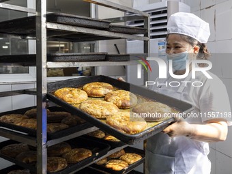 A worker prepares mooncakes for packaging at the production workshop of Oriental Pastry Co., LTD., a time-honored pastry company in Taizhou,...