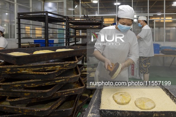 Workers make mooncakes at the production workshop of Dongfang Pastry Co., LTD., a time-honored pastry company in Taizhou, China, on Septembe...