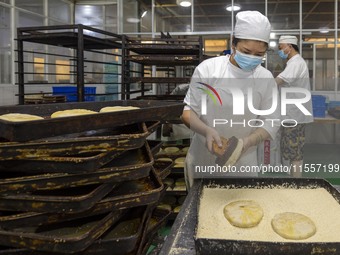 Workers make mooncakes at the production workshop of Dongfang Pastry Co., LTD., a time-honored pastry company in Taizhou, China, on Septembe...