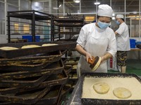 Workers make mooncakes at the production workshop of Dongfang Pastry Co., LTD., a time-honored pastry company in Taizhou, China, on Septembe...