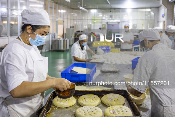 Workers make mooncakes at the production workshop of Dongfang Pastry Co., LTD., a time-honored pastry company in Taizhou, China, on Septembe...