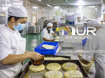 Workers make mooncakes at the production workshop of Dongfang Pastry Co., LTD., a time-honored pastry company in Taizhou, China, on Septembe...