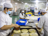 Workers make mooncakes at the production workshop of Dongfang Pastry Co., LTD., a time-honored pastry company in Taizhou, China, on Septembe...