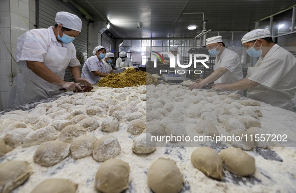 Workers make mooncakes at the production workshop of Dongfang Pastry Co., LTD., a time-honored pastry company in Taizhou, China, on Septembe...