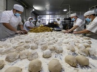 Workers make mooncakes at the production workshop of Dongfang Pastry Co., LTD., a time-honored pastry company in Taizhou, China, on Septembe...