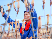 A worker dries squid at a seafood processing company in Zhoushan, China, on September 8, 2024. (