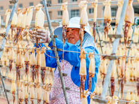 A worker dries squid at a seafood processing company in Zhoushan, China, on September 8, 2024. (