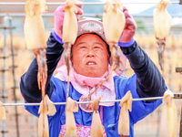 A worker dries squid at a seafood processing company in Zhoushan, China, on September 8, 2024. (