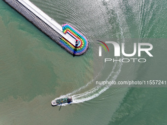 Coastal fishermen drive a fishing boat to transport oyster cage seedlings to a breeding area for spreading and stocking in Lianyungang, Chin...