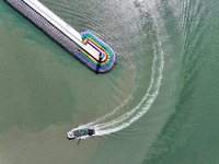 Coastal fishermen drive a fishing boat to transport oyster cage seedlings to a breeding area for spreading and stocking in Lianyungang, Chin...