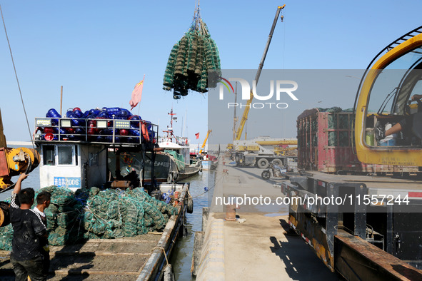 Fishermen hoist oyster cage seedlings for sea release in Lianyungang, China, on September 8, 2024. 